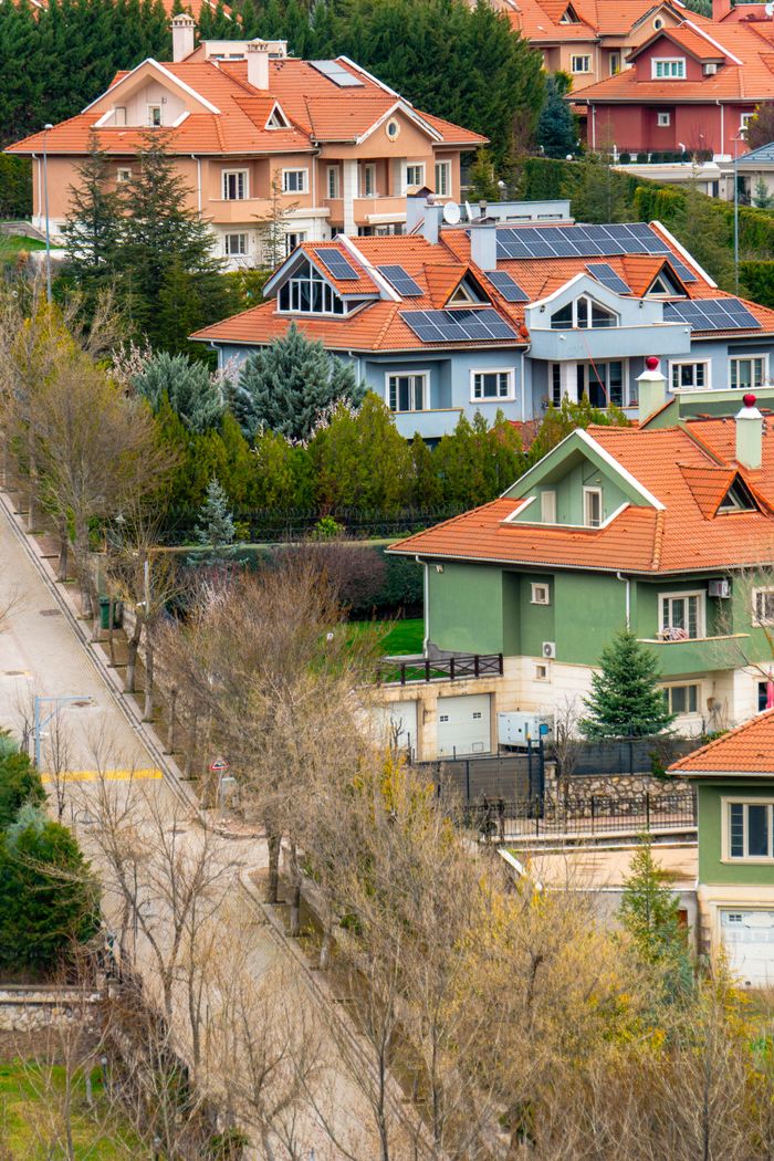 services-04 Charming suburban homes with solar panels in Ankara, Turkey, amidst lush greenery.