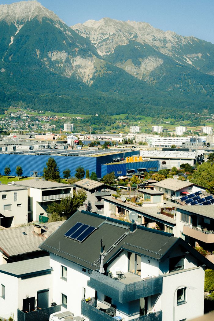 gallery-04 Stunning aerial view of Innsbruck, Austria, showcasing modern and traditional architecture against the majestic Alps.