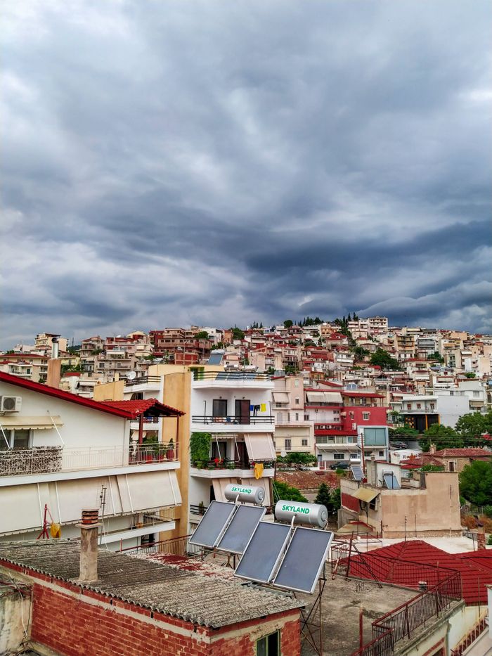 gallery-02 Vibrant urban cityscape of Lamia, Greece showcasing colorful homes and stormy skies.