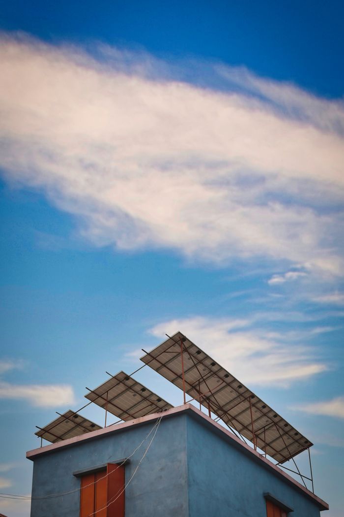 our-services-01 Solar panels mounted on a rooftop against a clear blue sky.