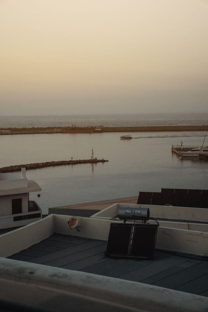 about-us-02 Serene coastal scene at sunset featuring a rooftop solar panel and tranquil waters.